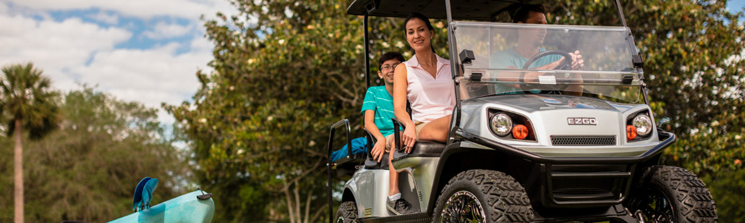 A family riding in a 2020 E-Z-GO EXPRESS S6 golf cart after service.